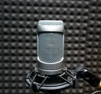 A microphone is sitting in front of some sound foam.